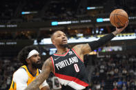 Portland Trail Blazers guard Damian Lillard (0) catches a pass as Utah Jazz guard Mike Conley, left, defends in the first half during an NBA basketball game Monday, Nov. 29, 2021, in Salt Lake City. (AP Photo/Rick Bowmer)