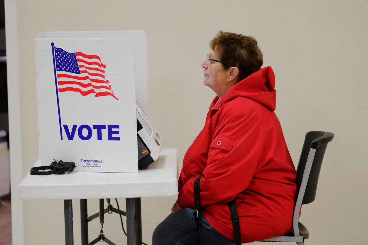 Candy Handl looks over voting instructions at the Open Bible Church poll, Tuesday, November 8, 2022, in Manitowoc, Wis.
