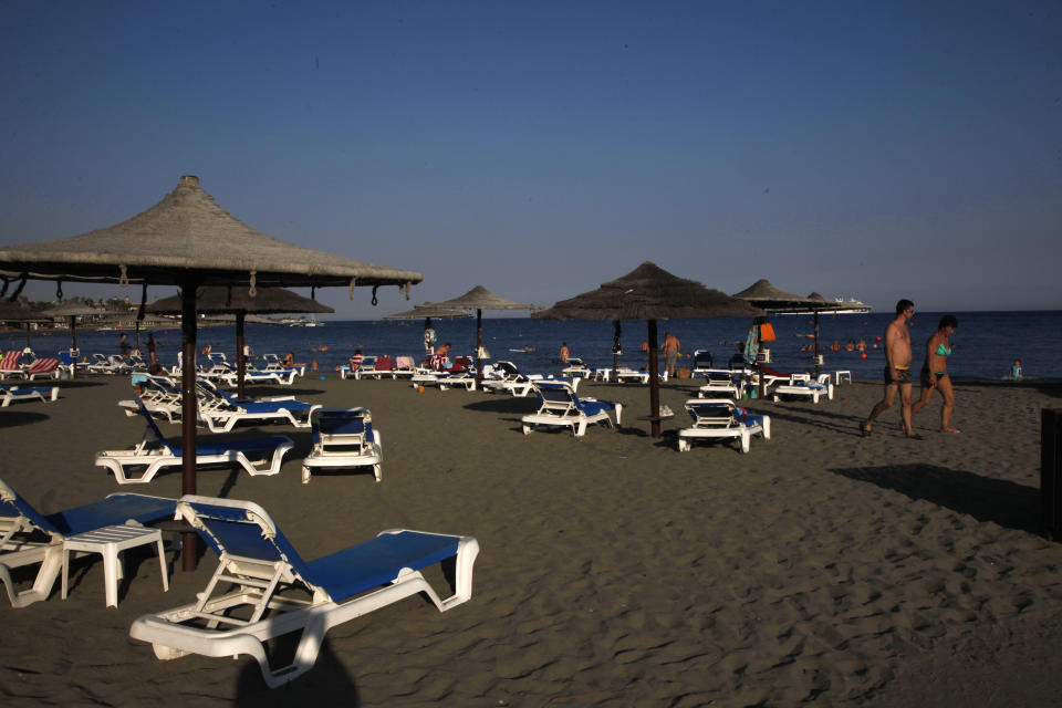 People enjoy the sea at Saint Rafael beach in southern coastal city of Limassol, Cyprus, on Wednesday, July 29, 2020. Cyprus' Tourism Minister Savvas Perdios says the country doesn't expect to receive this year more than 20-25% of the record 3.97 million holidaymakers it welcomed in 2019 as the coronavirus pandemic has so far shut out its key tourism markets. (AP Photo/Petros Karadjias)