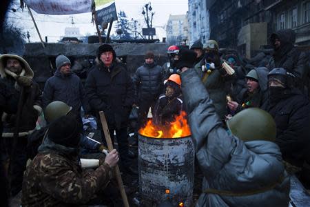 Anti-government protesters discuss the resignation of Ukrainian Prime Minister Mykola Azarov behind fortifications against riot police in Kiev, January 28, 2014. REUTERS/Thomas Peter