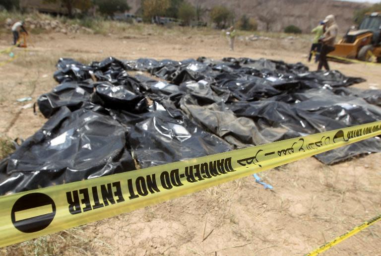 Body-bags containing the remains of people believed to have been slain by jihadists of the Islamic State (IS) group lie on the ground at the Speicher camp in the Iraqi city of Tikrit, on April 12, 2015