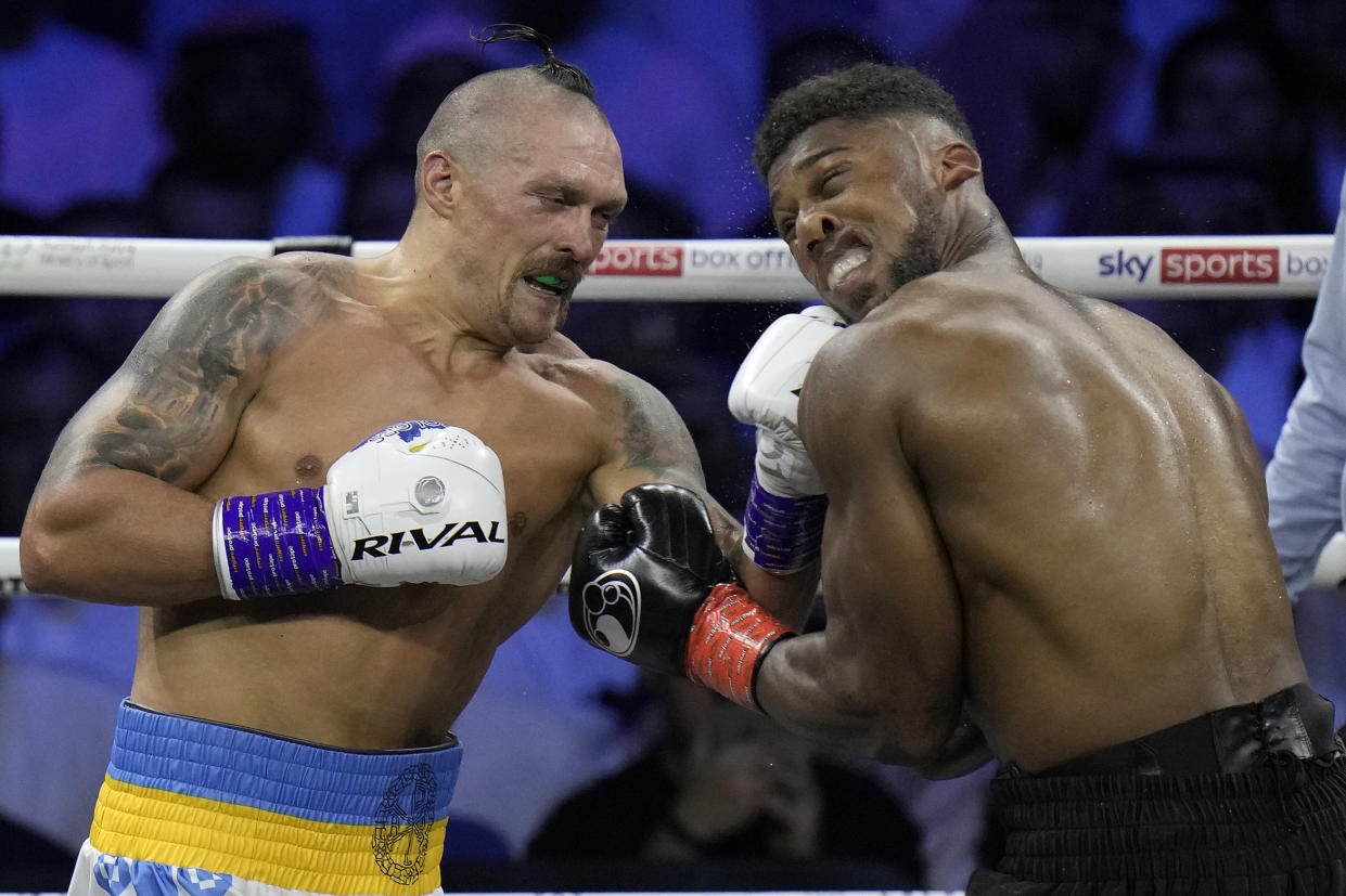 Britain's Anthony Joshua, right, takes a blow from Ukraine's Oleksandr Usyk during their world heavyweight title fight at King Abdullah Sports City in Jeddah, Saudi Arabia, Sunday, Aug. 21, 2022. (AP Photo/Hassan Ammar)