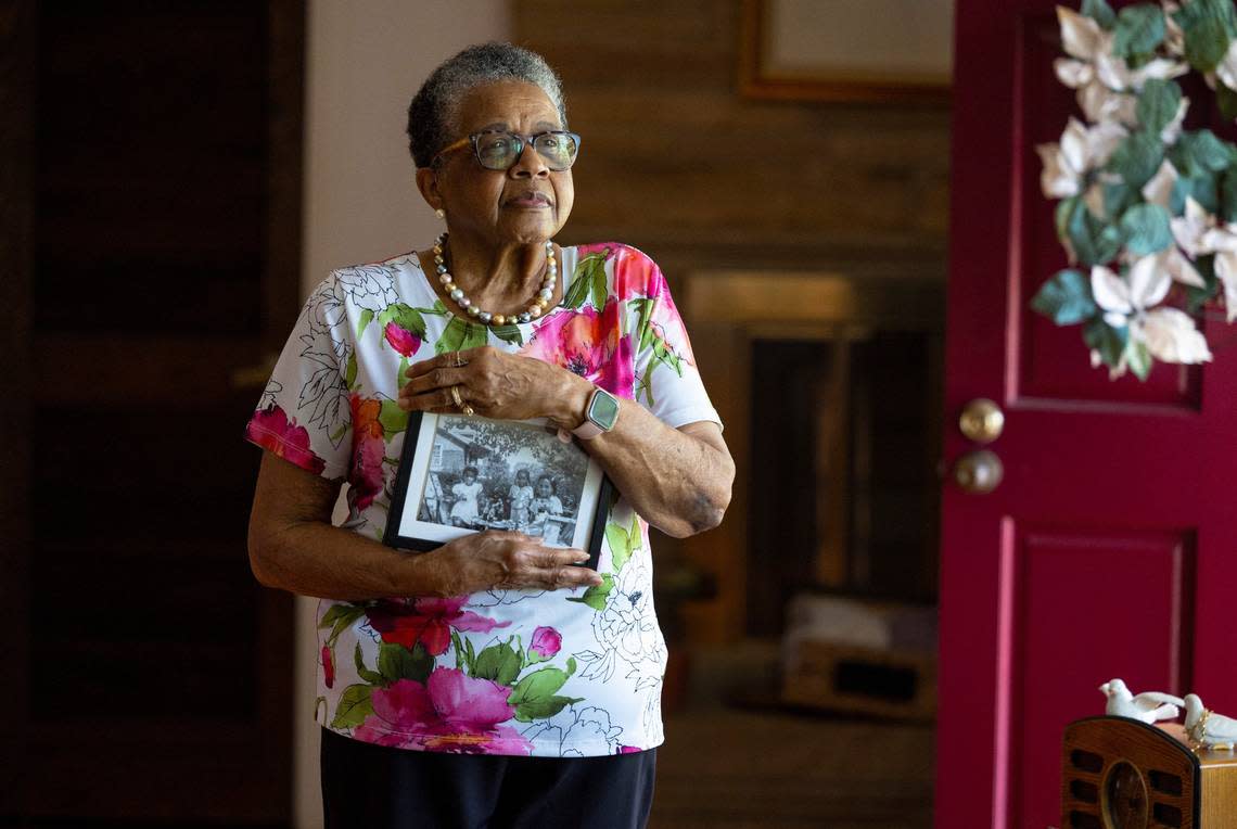 Majorie Tucker Keith poses with a late 1940s photo of her and her friends having a tea party outside the home she grew up in in Oberlin Village in Raleigh, N.C. Keith was photographed in her home Saturday, June 24, 2023.