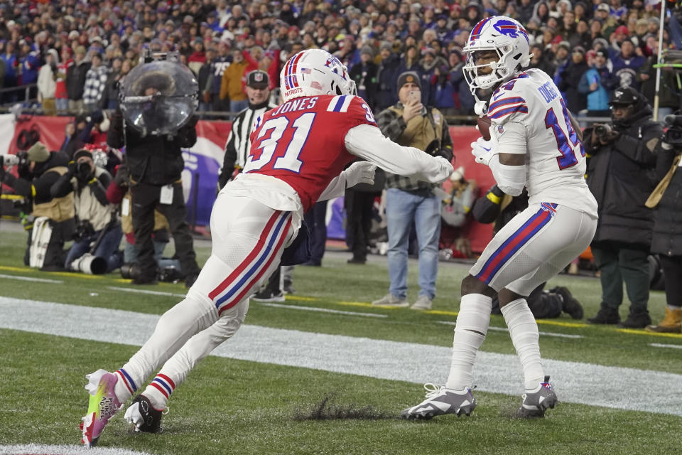 Buffalo Bills wide receiver Stefon Diggs (14) hangs onto the ball on his touchdown catch against New England Patriots cornerback Jonathan Jones (31) during the first half of an NFL football game, Thursday, Dec. 1, 2022, in Foxborough, Mass. (AP Photo/Steven Senne)