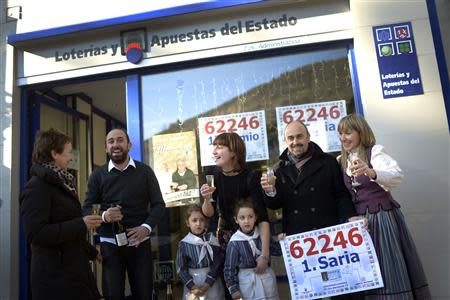 The Garai family, owners of a lottery shop which sold part of the first prize of Spain's Christmas Lottery "El Gordo" (The Fat One) , amounting to 172 million euros, celebrate outside their shop in Mondragon, December 22, 2013. REUTERS/Andrea Comas REUTERS/Vincent West