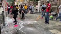 People and protesters help cleaning up the blue dye that stained steps of the Kowloon Masjid and Islamic Centre in Hong Kong