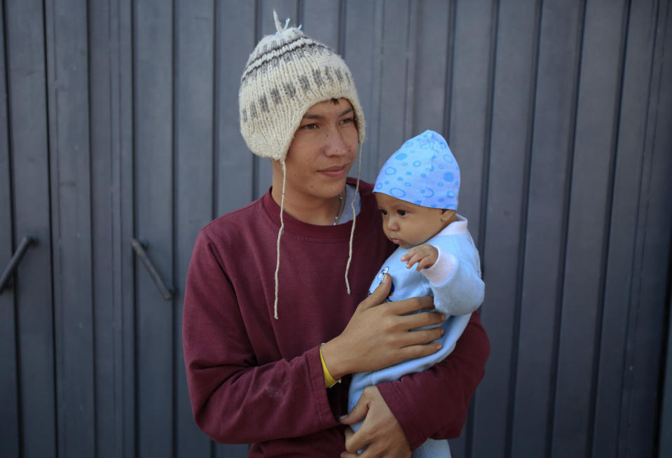 Jose Pedro Rosales Fernandez, 18, from Progreso, Honduras, holds his four-month-old son Dariel, inside the sports complex where thousands of migrants have been camped out for several days in Mexico City, Friday, Nov. 9, 2018. About 500 Central American migrants headed out of Mexico City on Friday to embark on the longest and most dangerous leg of their journey to the U.S. border, while thousands more were waiting one day more at a massive improvised shelter.(AP Photo/Rebecca Blackwell)