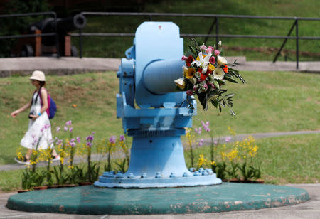 A woman walks past a cannon which is decorated with flowers at Fort Siloso as a symbolic gesture of peace, ahead of the June 12 summit between U.S. President Donald Trump and North Korean leader Kim Jong Un, on Singapore's resort island of Sentosa, June 9, 2018. REUTERS/Kim Kyung-Hoon