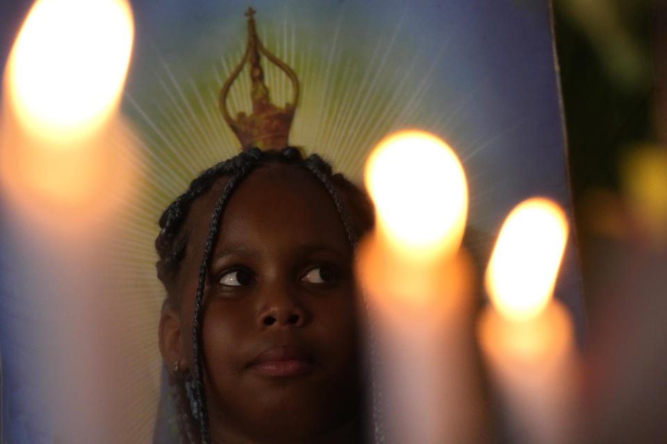 A girl, member of the Kalunga quilombo, descendants of runaway slaves, attends the coronation of the Emperor of the Holy Spirit, during the culmination of the week-long pilgrimage and celebration for the patron saint "Nossa Senhora da Abadia" or Our Lady of Abadia, in the rural area of Cavalcante in Goias state, Brazil, Sunday, Aug. 14, 2022. (AP Photo/Eraldo Peres)