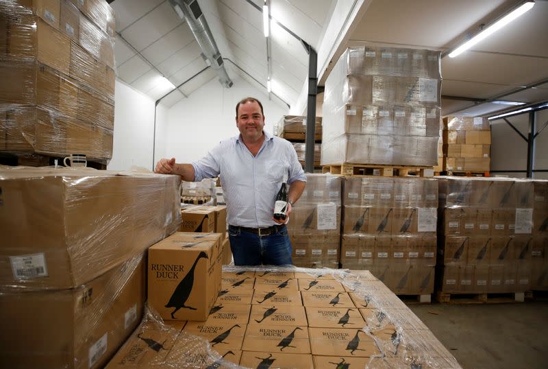 Shaun Mcvey of Vergenoegd Low Wine Estate stands amongst cases of Runner Duck wines, near Cape Town