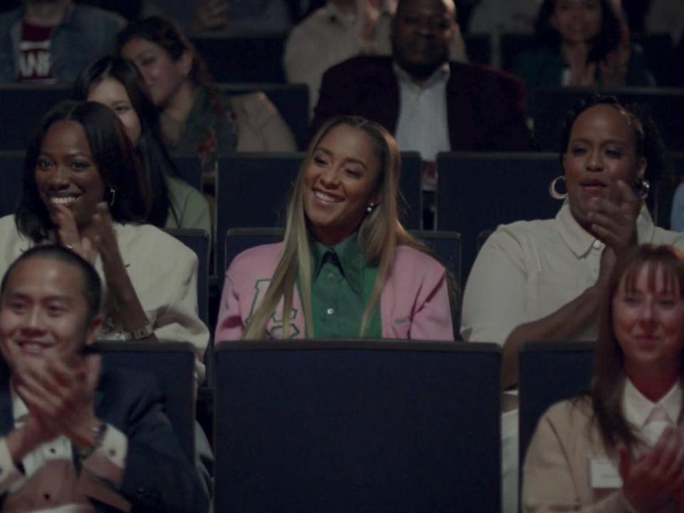 Three women are in focus among a theater of audience members in an episode of "Insecure."