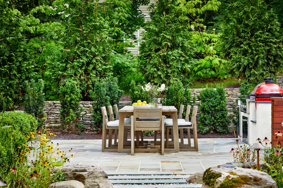 An outdoor dining with a grill next to it