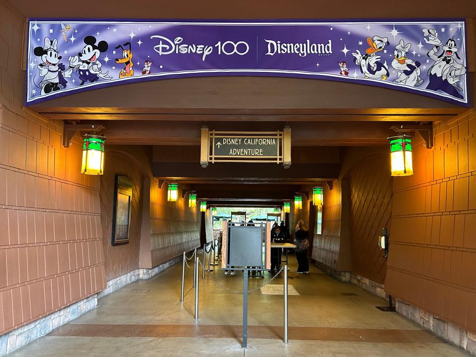 The entrance to Disney California Adventure, with a large purple Disney 100 banner featuring classic Disney characters.