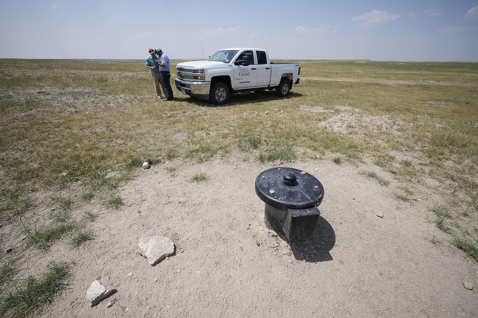 In this Monday, July 26, 2021, photograph, Cole Gustafson, a water resource administrator for the Greeley, Colo., Water Department, uses his mobile device to show the location of well heads on the Terry Bison Ranch near of Carr, Colo. Figures released this month show that population growth continues unabated in the South and West, even as temperatures rise and droughts become more common. That in turn has set off a scramble of growing intensity in places like Greeley to find water for the current population, let alone those expected to arrive in coming years. (AP Photo/David Zalubowski)