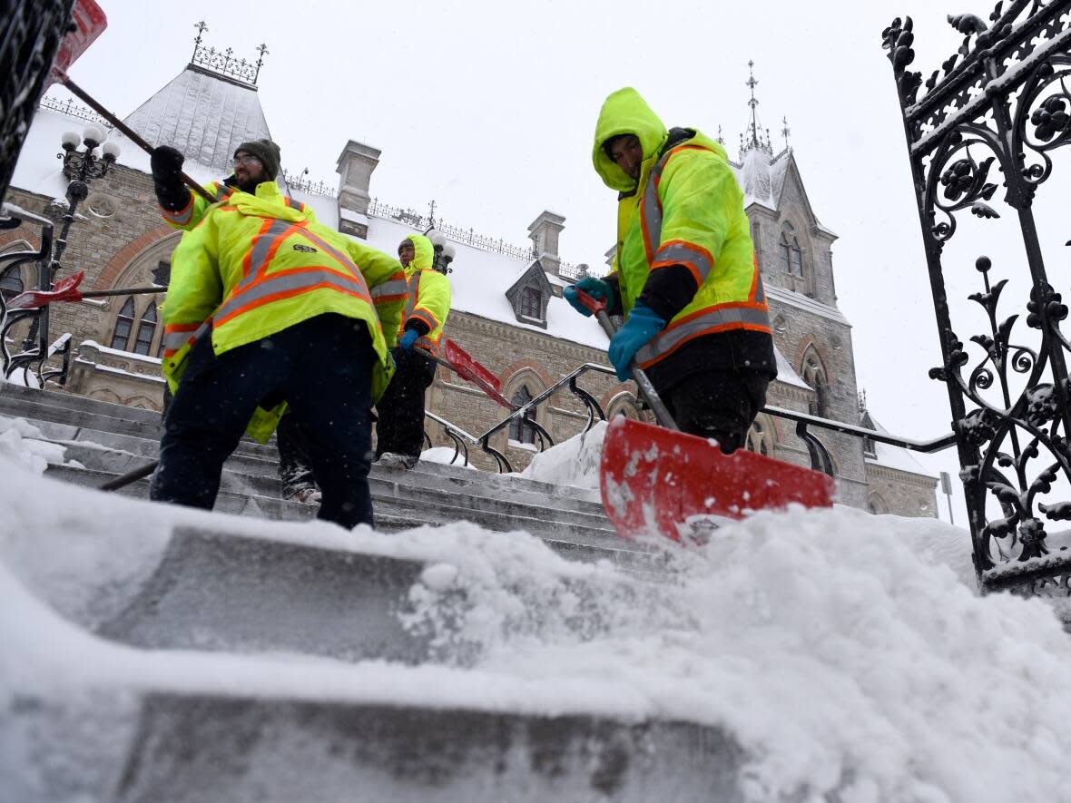 Crews clear snow from the steps in front of the West Block on Parliament Hill in Ottawa during the winter storm on Monday. (Justin Tang/The Canadian Press - image credit)