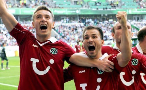 (From left) Hanover's Polish striker Artur Sobiech, midfielder Szabolcs Huszti and Konstantin Rausch celebrate after scoring during the German first division Bundesliga match against Wolfsburg in Wolfsburg. Ten-man Wolfsburg suffered their worst Bundesliga home defeat this century after they were routed 4-0 by Hanover 96