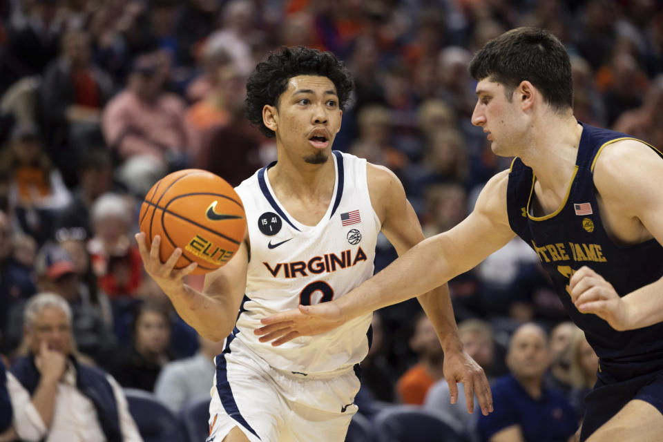 Virginia's Kihei Clark (0) looks to pass the ball against Notre Dame during the second half of an NCAA college basketball game in Charlottesville, Va., Saturday, Feb. 18, 2023. (AP Photo/Mike Kropf)