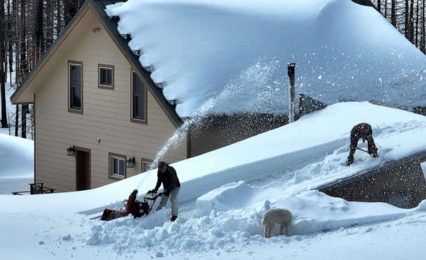 PHOTO: Residents are seen using a snow blower to clear snow from the room of a home on March 20, 2023 in Twin Bridges, California. (Justin Sullivan/Getty Images)