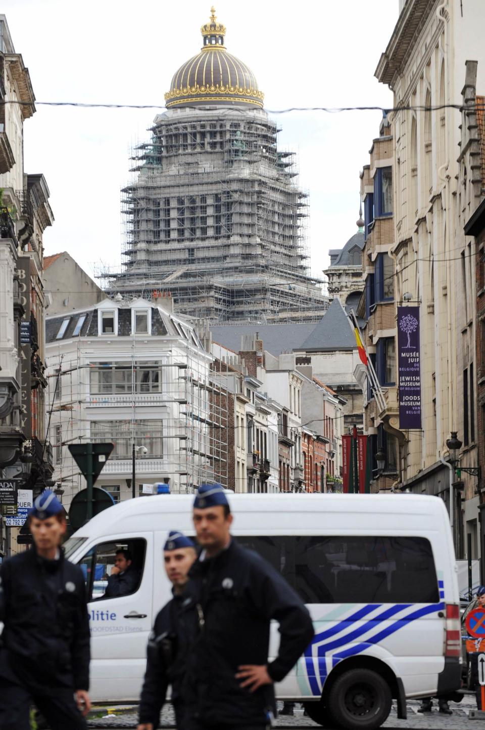 Policemen and a police vehicle are seen at the site of a shooting in Brussels