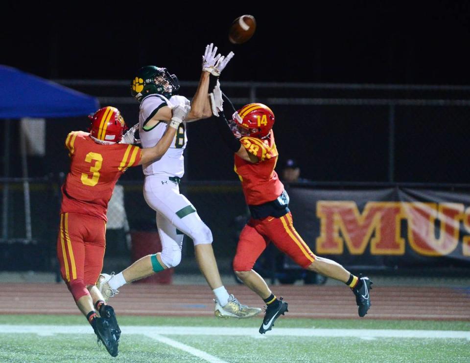 Sonora receiver Eli Ingalls leaps to attempt a catch between two Oakdale defenders during a game between Oakdale High School and Sonora High School at Oakdale High School in Oakdale California CA on August 18, 2023.