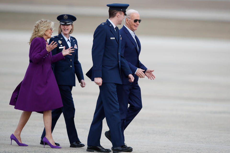 President Joe Biden, right, is escorted by Air Force Cpt. Eric Anderson, 89th Airlift Wing Flightline protocol officer, as first lady Jill Biden, left, talks to Col. Angela Ochoa, commander of the 89th Airlift Wing, (Luis M. Alvarez / AP)