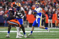 Pittsburgh quarterback Kenny Pickett, right, looks to pass during the first half of an NCAA college football game against Syracuse in Syracuse, N.Y., Saturday, Nov. 27, 2021. (AP Photo/Adrian Kraus)