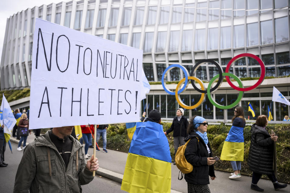 Members of the Geneva branch of Ukrainian society in Switzerland protest during a rally to urge International Olympic Committee to reconsider their decision of participation of Russian and Belarusian athletes under white neutral flag at the next 2024 Paris Olympic Games, in front of the IOC headquarters, in Lausanne, Switzerland, Saturday, March 25, 2023. (Jean-Christophe Bott/Keystone via AP)