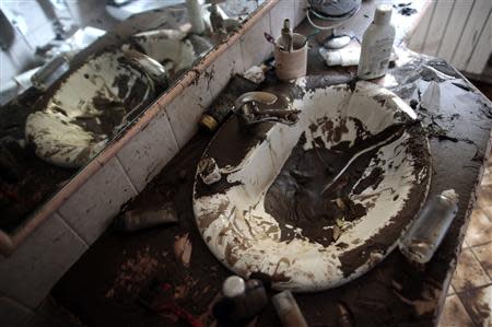 A sink is seen covered in mud in a bathroom of a house following extreme rainfall in Olbia on Sardinia island November 20, 2013. REUTERS/Tony Gentile