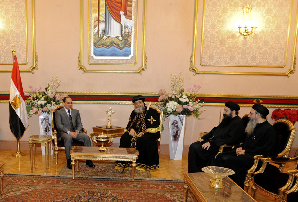 Egypt's former military chief Abdel-Fattah el-Sissi, left, meets with Coptic Pope Tawadros II, center, at Cairo’s St. Mark’s Cathedral, seat of the Coptic Orthodox Pope, in Cairo, Egypt, Saturday, April 19, 2014. El-Sissi on Monday took the final formal step to run in next month's presidential election, submitting to the election commission eight times the number of signatures required. He is widely expected to win. (AP Photo/Girgis Mahboub, Office of the Coptic Pope)