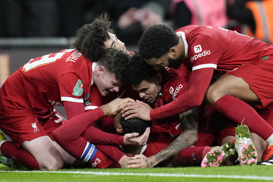 Liverpool's Virgil van Dijk celebrates, surrounded by team mates, after scoring his side's first goal during the English League Cup final soccer match between Chelsea and Liverpool at Wembley Stadium in London, Sunday, Feb. 25, 2024. (AP Photo/Alastair Grant)