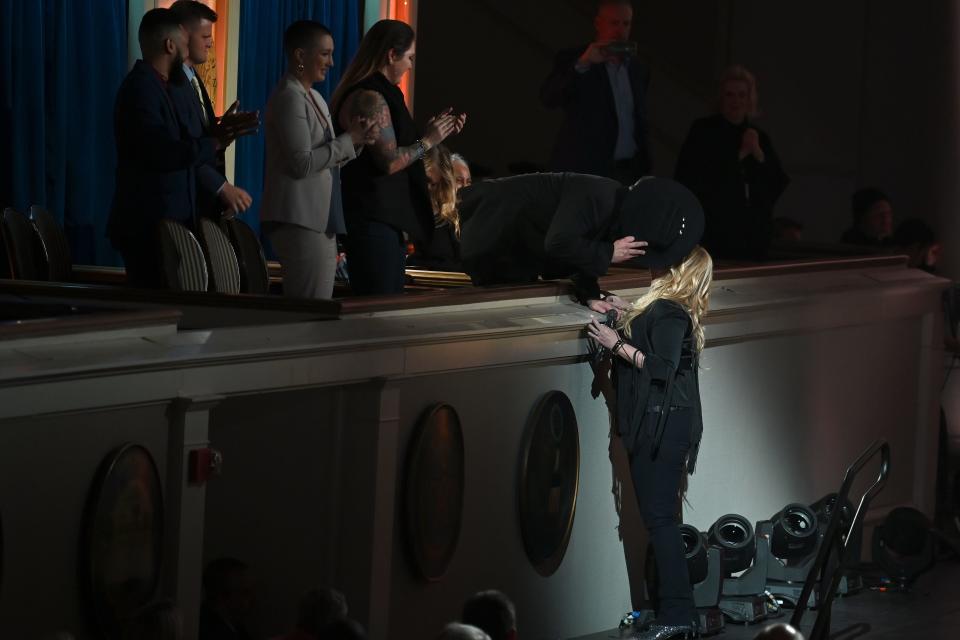 Garth Brooks bends down to kiss Trisha Yearwood after she performs.