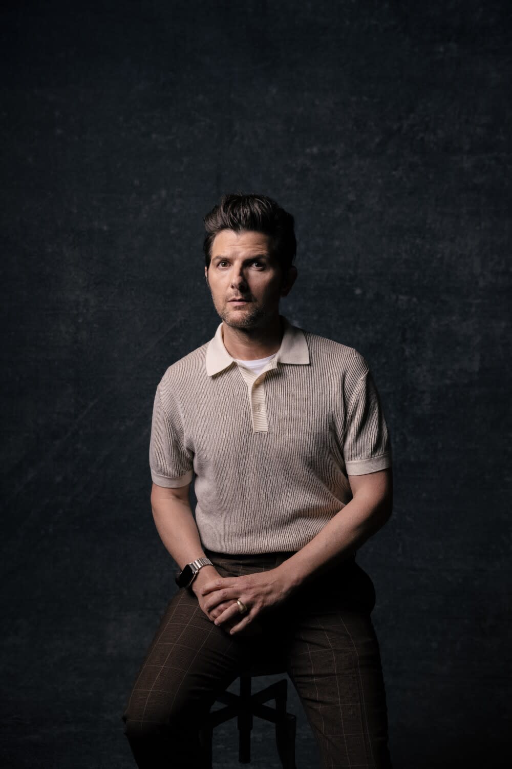 Adam Scott sits on a stool for a portrait.