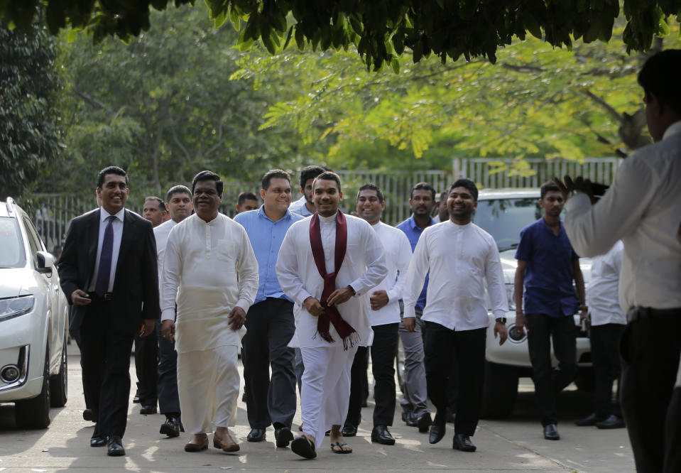 Namal, center wearing a red scarf, a Sri Lankan lawmaker and elder son of disputed Prime Minister Mahinda Rajapaksa, arrives with other lawmakers at the supreme court complex in Colombo, Sri Lanka, Thursday, Dec. 13, 2018. Sri Lanka's Supreme Court unanimously ruled as unconstitutional President Maithripala Sirisena's order to dissolve Parliament and call for fresh elections, a much-anticipated verdict Thursday that further embroils the Indian Ocean island nation in political crisis. (AP Photo/Eranga Jayawardena)