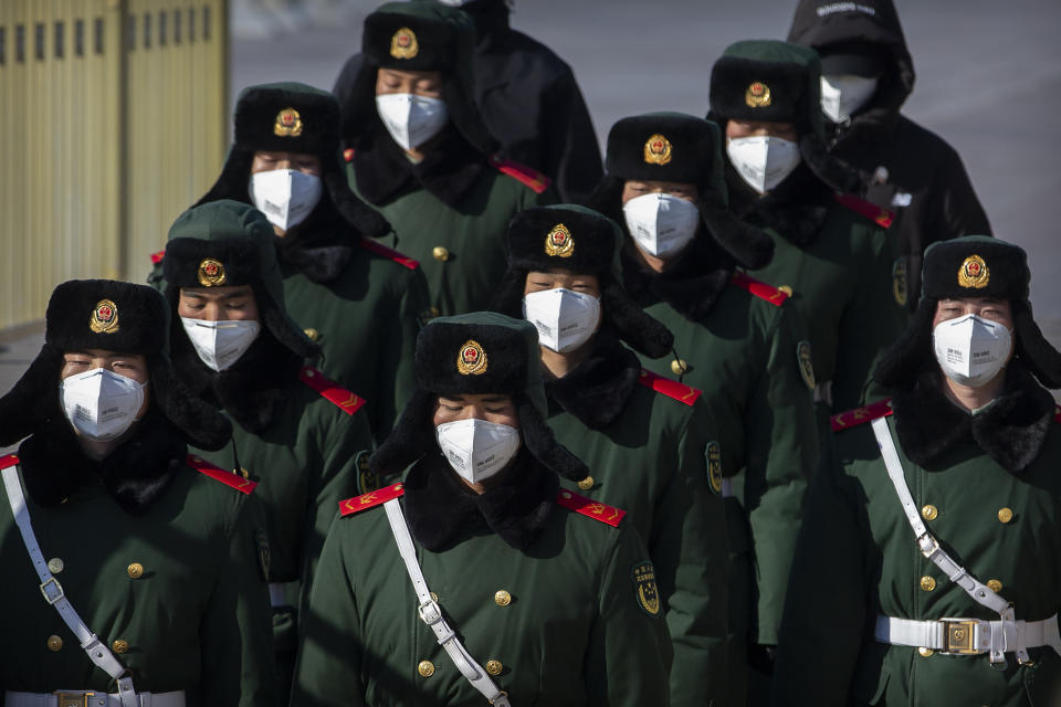 FILE - Paramilitary police officers wear face masks as they march in formation into a pedestrian underpass next to Tiananmen Square in Beijing, Tuesday, Feb. 4, 2020. (AP Photo/Mark Schiefelbein, File)