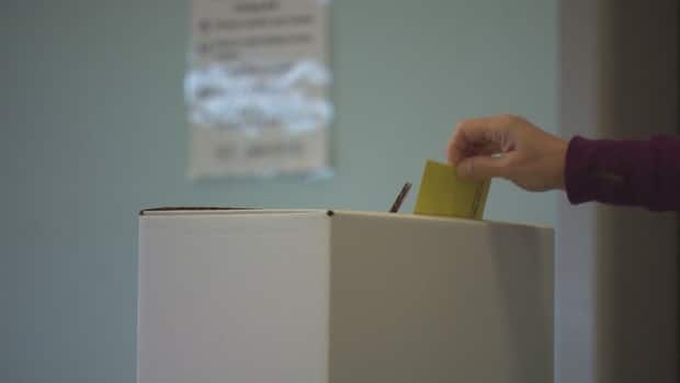 A voter drops their ballot into a ballot box for the 2021 St. John's municipal election. (Curtis Hicks/CBC - image credit)