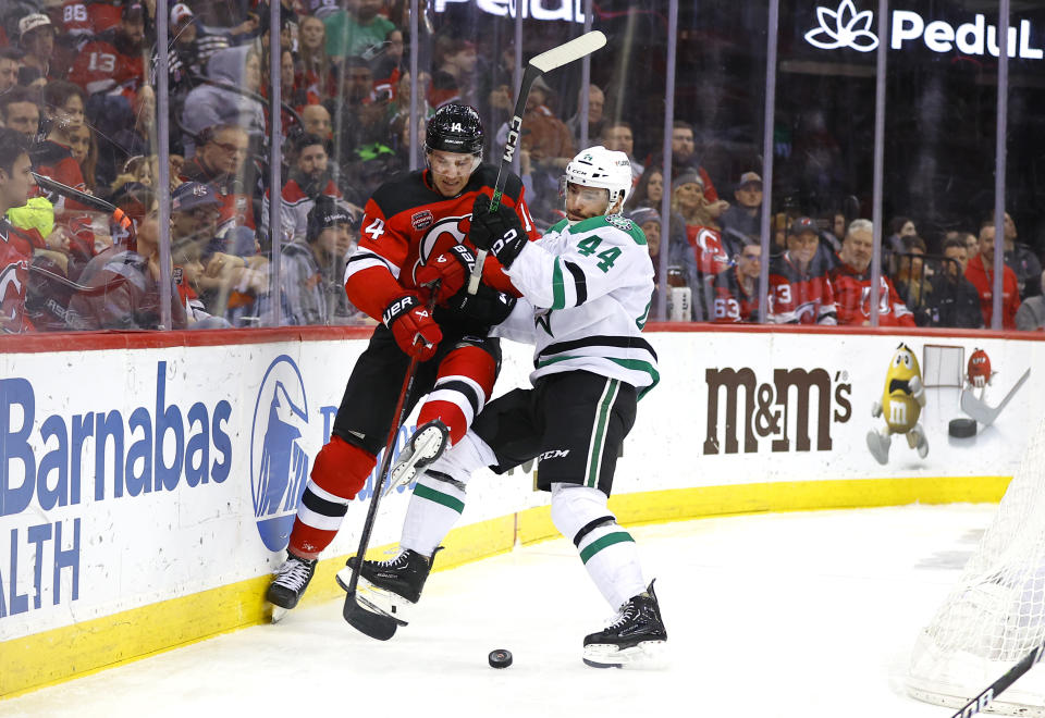 Dallas Stars defenseman Joel Hanley (44) checks New Jersey Devils right wing Nathan Bastian (14) during the second period of an NHL hockey game Saturday, Jan. 20, 2024, in Newark, N.J. (AP Photo/Noah K. Murray)