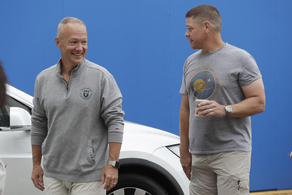 NASA astronauts Douglas Hurley, left, and Robert Behnken walk outside the Neil A. Armstrong Operations and Checkout Building, at the Kennedy Space Center in Cape Canaveral, Fla., Wednesday, May 27, 2020. The two astronauts will fly on a SpaceX test flight to the International Space Station. For the first time in nearly a decade, astronauts will blast into orbit aboard an American rocket from American soil, a first for a private company. (AP Photo/John Raoux)