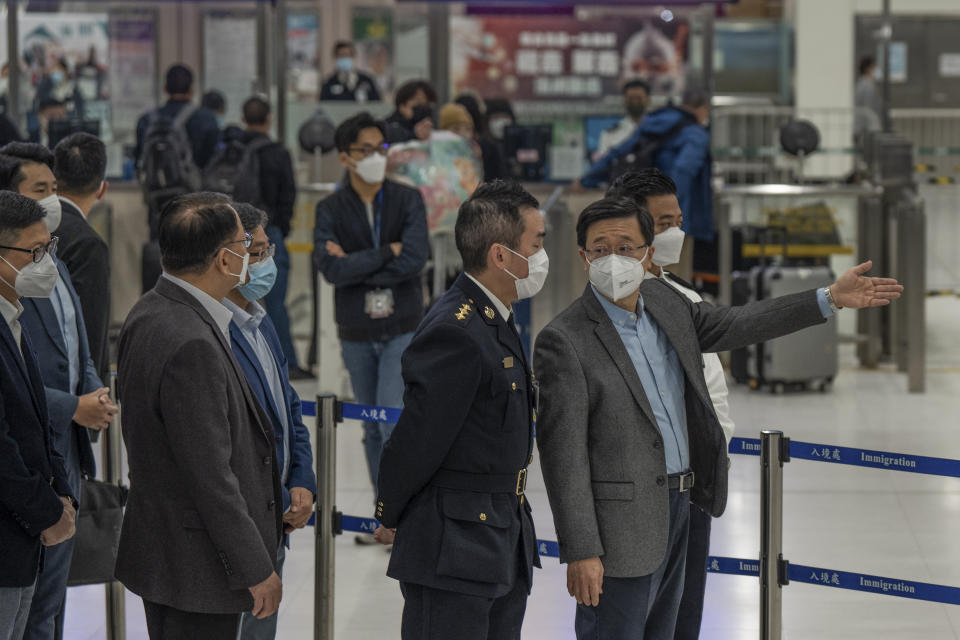 Hong Kong Chief Executive John Lee, right, speaks to an officer as he inspects Lok Ma Chau station following the reopening of crossing border with mainland China, in Hong Kong, Sunday, Jan. 8, 2023. Travelers crossing between Hong Kong and mainland China, however, are still required to show a negative COVID-19 test taken within the last 48 hours, a measure China has protested when imposed by other countries. (AP Photo/Bertha Wang)