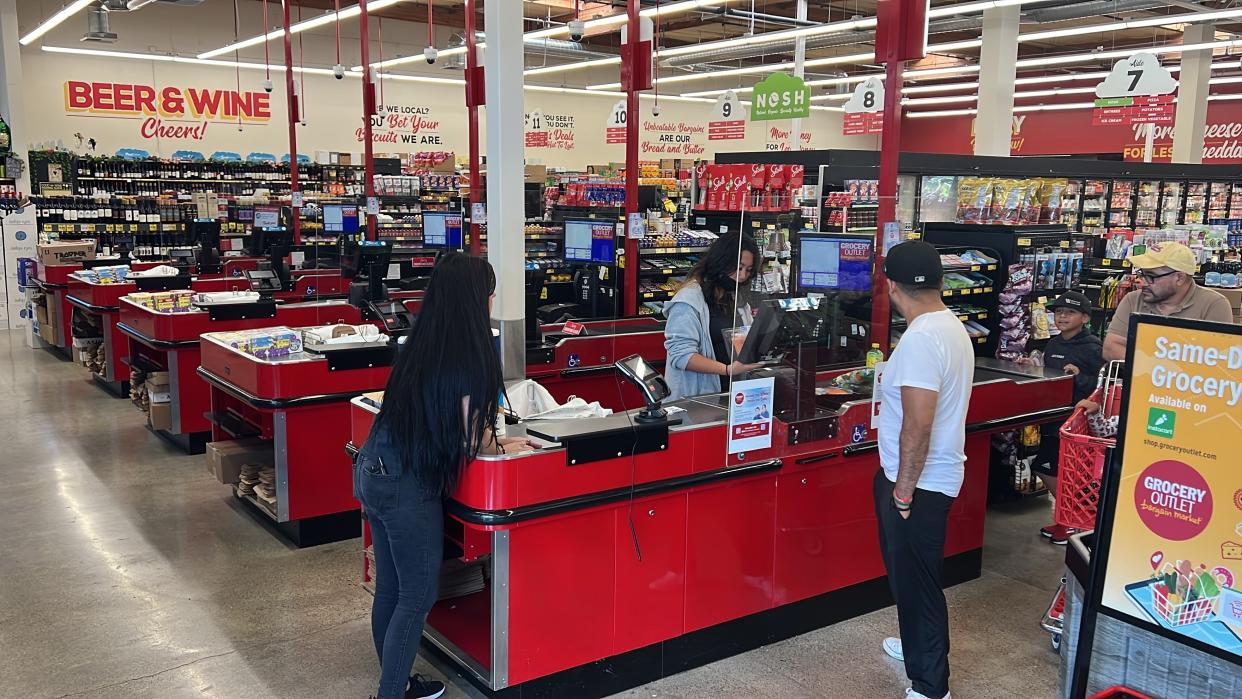 Customers check out at a Grocery Outlet store in Pleasanton, Calif. on Thursday, Sept. 15, 2022. "Best before” labels are coming under scrutiny as concerns about food waste grow around the world. Manufacturers have used the labels for decades to estimate peak freshness. But “best before” labels have nothing to do with safety, and some worry they encourage consumers to throw away food that’s perfectly fine to eat. (AP Photo/Terry Chea)