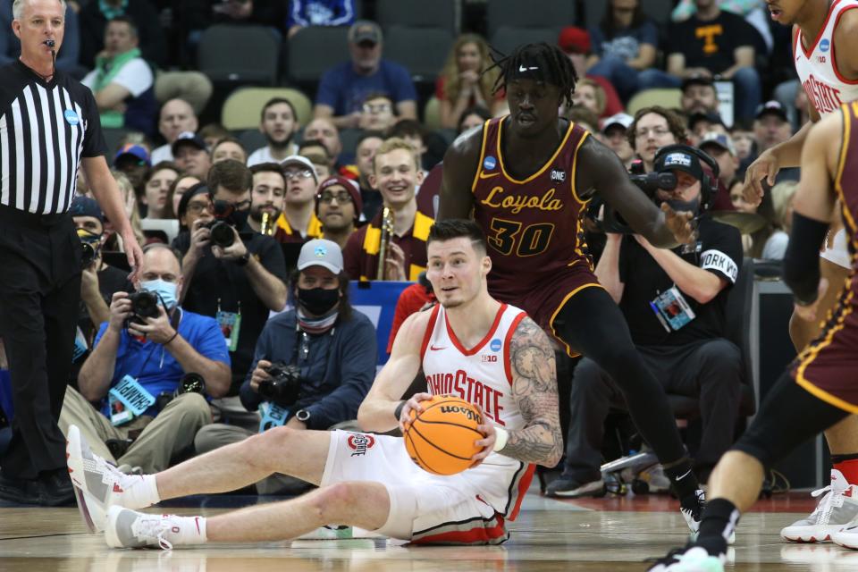 Ohio State's Kyle Young looks to pass after diving to the floor to retrieve a loose ball on Friday.