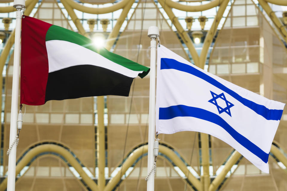 FILE, -The Emirati and Israeli flags fly overhead as Israeli President Isaac Herzog gives a speech at Expo 2020 in Dubai, United Arab Emirates, Monday, Jan. 31, 2022. When Israel struck an agreement to establish diplomatic ties with the United Arab Emirates in 2020, but two years after an expected windfall of Gulf Arab tourists to Israel has been little more than a trickle.(AP Photo/Jon Gambrell, File)