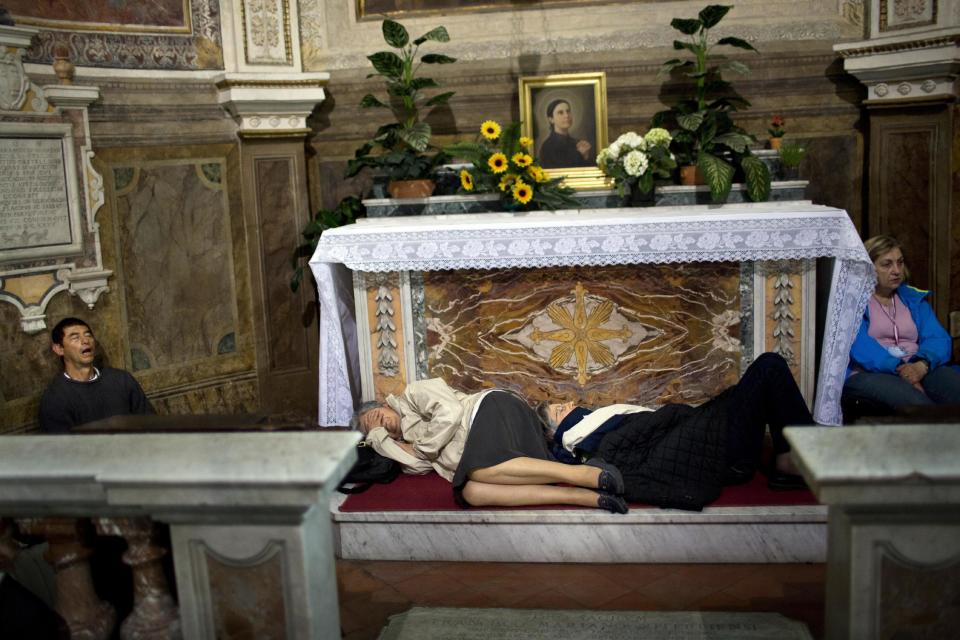 Pilgrims sleep inside a church near St. Peter's Square waiting to attend the ceremony for the canonization of Pope John XXIII and Pope John Paul II, in Rome, early Sunday, April 27, 2014. Pilgrims and tourists streamed into Rome to participate in the ceremony in St. Peter's Square that will see two popes, John XXIII and John Paul II, be proclaimed saints. (AP Photo/Emilio Morenatti)