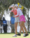 Nelly Korda, left, celebrates with her sister Jennifer, right, walking off the 18th green after winning the Gainbridge LPGA golf tournament Sunday, Feb. 28, 2021, in Orlando, Fla. (AP Photo/Stan Badz)