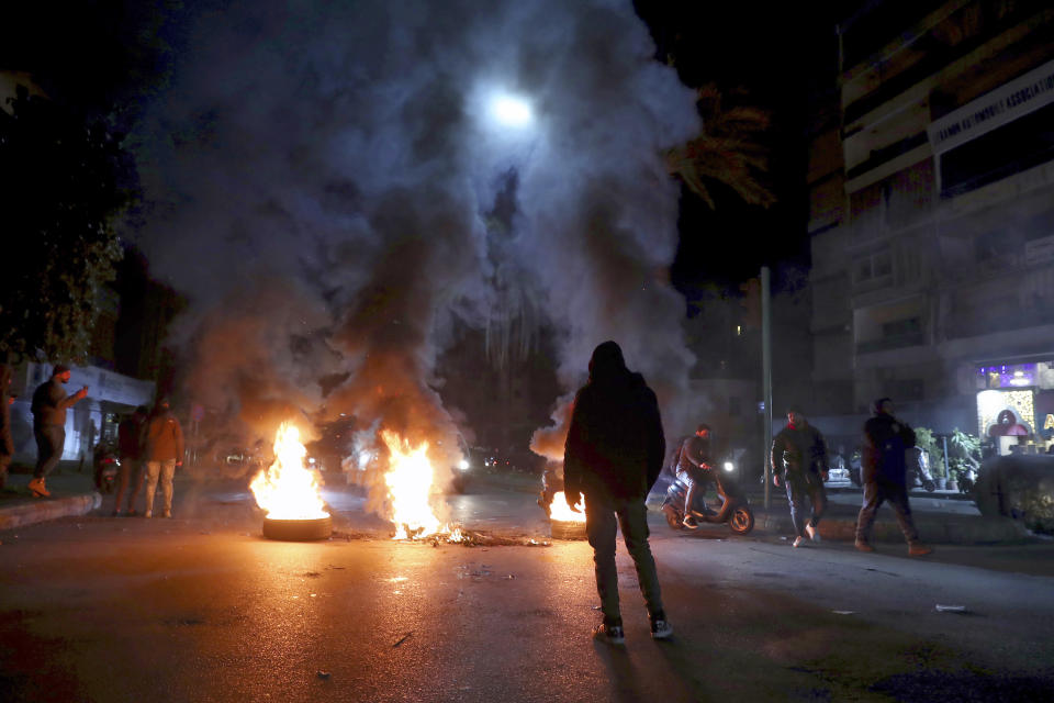 Supporters of former Prime Minister Saad Hariri burn tires to block a main road in Beirut, Lebanon, Monday, Jan. 24, 2022. On Monday Hariri said he is suspending his work in politics and will not run in May's parliamentary elections. (AP Photo/Bilal Hussein)