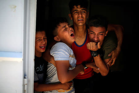 Relatives of a Palestinian, who was killed at the Israel-Gaza border, react at a hospital in Gaza City June 18, 2018. REUTERS/Mohammed Salem