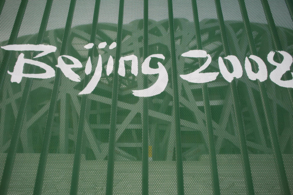 FILE - A protective fence shows a Beijing 2008 logo outside the National Stadium, known as the "Birds Nest," in Beijing on Aug. 7, 2008. Ai is one of China's most famous artists, and many regard him as one of the world's greatest living artists. Working with the Swiss architectural firm Herzog & de Meuron, he helped design the Bird's Nest stadium, the centerpiece of Beijing's 2008 Summer Olympics. The stadium will also host the opening ceremony for Beijing's Winter Olympics on Feb. 4, 2022. (AP Photo/Petr David Josek, File)