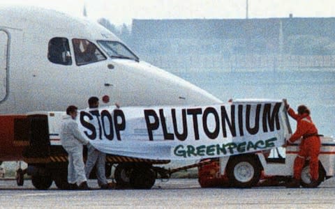 Greenpeace protesters try to block a cargo plane loaded with radioactive plutonium in Belgium - Credit: PETER MAENHOUDT/AP