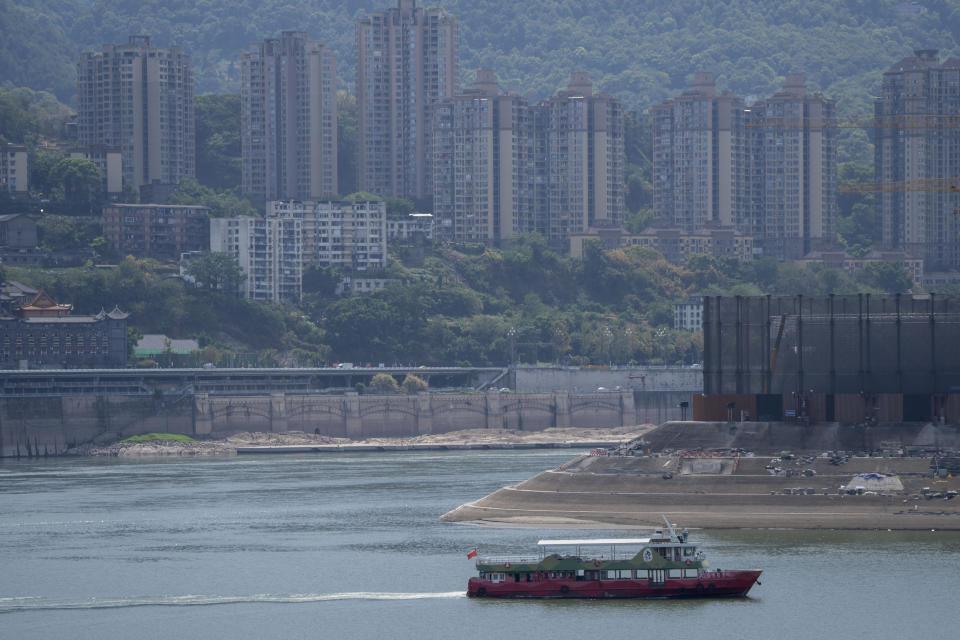 A ship navigates along the Jialing River near its meeting with the Yangtze River in southwestern China's Chongqing Municipality, Friday, Aug. 19, 2022. Ships crept down the middle of the Yangtze on Friday after the driest summer in six decades left one of the mightiest rivers shrunk to barely half its normal width and set off a scramble to contain damage to a weak economy in a politically sensitive year. (AP Photo/Mark Schiefelbein)