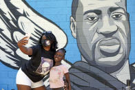 In this June 7, 2020, photo, Margaret Williams, left, takes a picture with her daughter, Nala, 8, in front of a mural honoring George Floyd in Houston’s Third Ward. Floyd, who grew up in the Third Ward, died after being restrained by Minneapolis police officers on Memorial Day. (AP Photo/David J. Phillip)