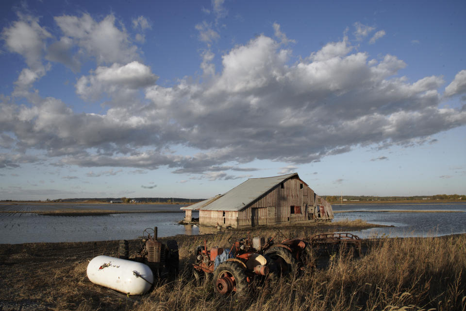 FILE - In this Oct. 22, 2019 photo, a barn sits in floodwaters in Pacific Junction, Iowa. Flooding remains a concern in several states along the Missouri River even though the weather has been kind so far this spring. The flood risk remains high in eastern South Dakota, eastern North Dakota, eastern Nebraska, western Iowa, eastern Kansas and Missouri because the soil remains wet, but the lack of rain and warm temperatures this spring allowed snow to melt gradually across the Plains without worsening the risk. (AP Photo/Nati Harnik File)